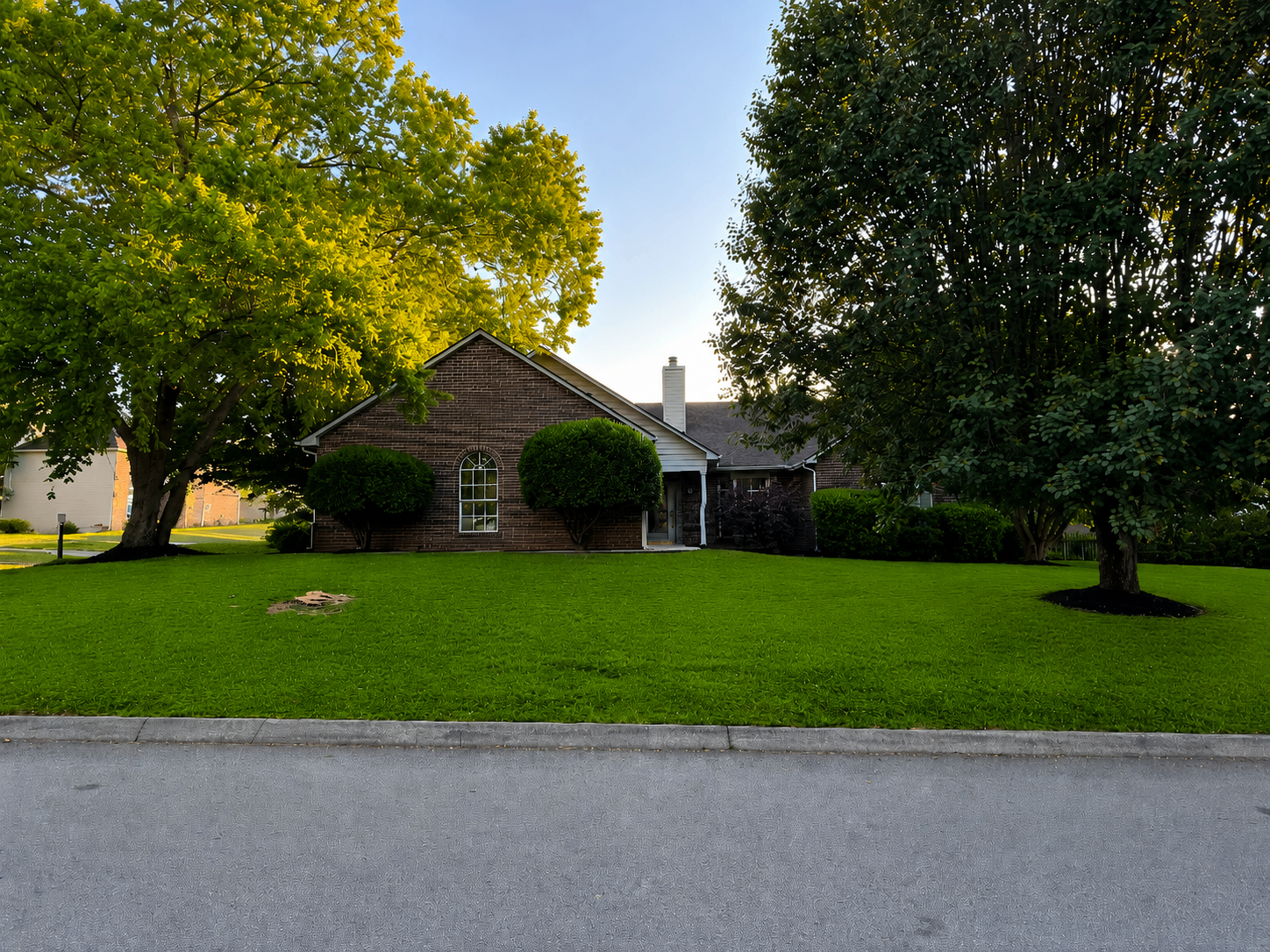 Brick home with lush manicured front lawn